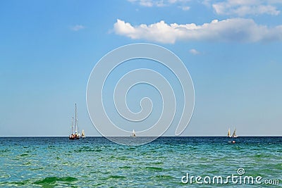 Summer seascape: the weather is sunny, the blue-green sea is calm, sky is blue and several sailing boats nearby Stock Photo