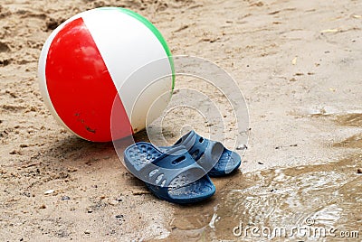 Summer slippers and Beach ball in sand Stock Photo