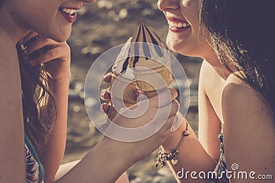 Summer style concept with couple of cheerful beautiful young women eating ice cream together in friendship - closeup of girls Stock Photo