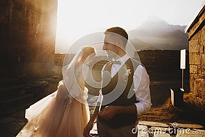 Summer sun shines over stunning wedding couple walking in lonely Georgian town Stock Photo