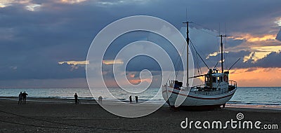 Summer sunset at Slettestrand, Denmark. Fishing boat on the beach. Stock Photo