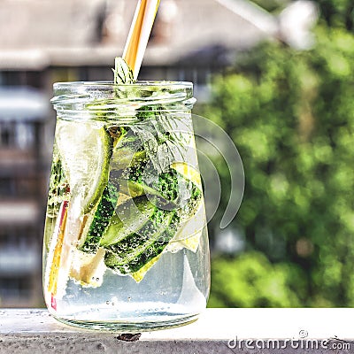 Detox drink from cucumber, lemon and mint on the background of a modern city. Summer time Stock Photo