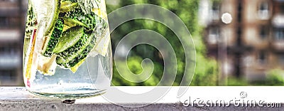 Detox drink from cucumber, lemon and mint on the background of a modern city. Summer time Stock Photo