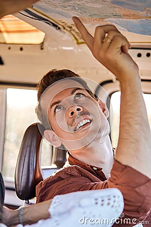 Summer travel concept. young man looking at map to plan a camper van trip Stock Photo