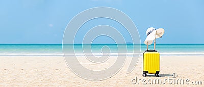 Summer traveling and tourism planning with yellow suitcase luggage with big hat fashion in the sand Stock Photo