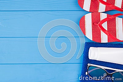 Summer vacation concept. Top above overhead view close-up photo of towel sunglasses sunscreen and flipflops isolated on blue Stock Photo