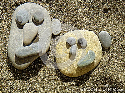 Summer vacation impressions - children laid various stone figurines on the sand Stock Photo