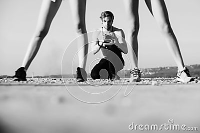 Summer vacation. Muscular man, photographer with camera and legs of women Stock Photo