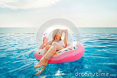 Summer Vacation. Woman in bikini on the inflatable donut mattress in the SPA swimming pool. Stock Photo