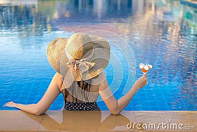 Summer Vacations. Lifestyle woman happy with bikini and big hat relaxing on the swimming pool, in holiday. Stock Photo