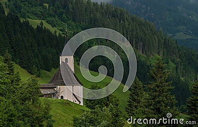 Summer valley with Grossarler Ache small river and blue cloudy sky and church Stock Photo