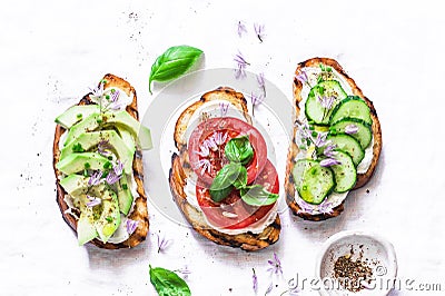 Summer variations of sandwiches - with cream cheese, avocado, tomato and cucumber on a light background, top view. Healthy diet fo Stock Photo