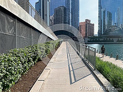 Summer view of Chicago riverwalk with shadows, greenery and commuters Editorial Stock Photo