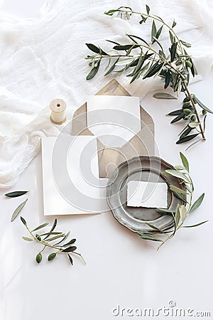 Summer wedding stationery mock-up scene. Blank greeting cards, envelope, vintage silver plate, olive branches and ribbon Stock Photo