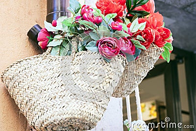 Summer wicker bags made of straw and rattan with textile flowers on the market in Taormina, Sicily, Italy Stock Photo
