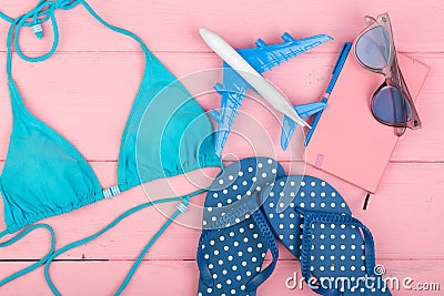 summer women`s fashion with blue swimsuit, sunglasses, smart phone, headphones and little airplane Stock Photo
