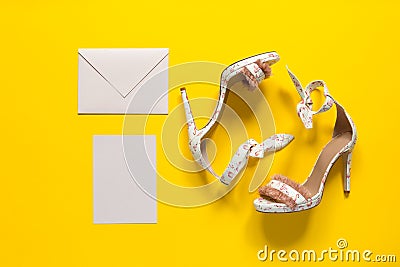 Summer women`s high-heeled shoes. Pink flamingos and feathers. Envelope and postcard. Yellow paper background Stock Photo