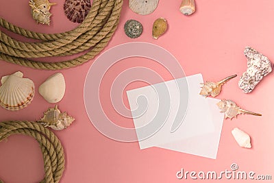 Summertime marine vacation background with lots of seashells, pebbles, nautical rope on pink background. There is a sheet of paper Stock Photo