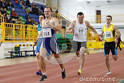 SUMY, UKRAINE - FEBRUARY 17, 2017: sportsmen running qualification race in the men`s 400m running in an indoor track and Editorial Stock Photo