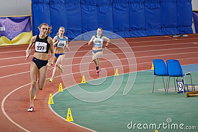 SUMY, UKRAINE - FEBRUARY 17, 2017: sportswomen compete in the women`s 400m running in an indoor track and field event. Editorial Stock Photo