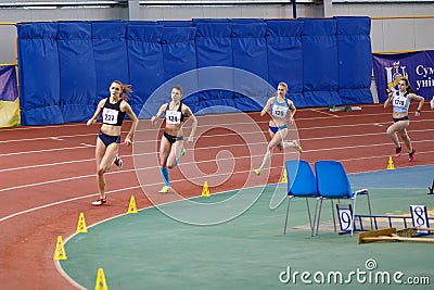 SUMY, UKRAINE - FEBRUARY 17, 2017: sportswomen compete in the women`s 400m running in an indoor track and field event. Editorial Stock Photo