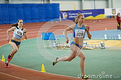 SUMY, UKRAINE - FEBRUARY 17, 2017: Viktoria Grynko #129 and Yulia Shulyar #1218 compete in the women`s 400m running Editorial Stock Photo