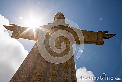 Sun behind Christus Rei Statue in Lisbon, Portugal Stock Photo