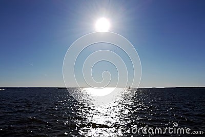 The Sun in the blue sky and the sun glare on the water Stock Photo