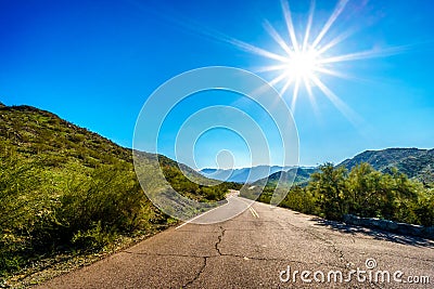 Sun casting its sun rays on the East San Juan Road near the San Juan Trail Head in the mountains of South Mountain Park Stock Photo