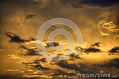 Sun casting long shadows and golden hue over clouds Stock Photo