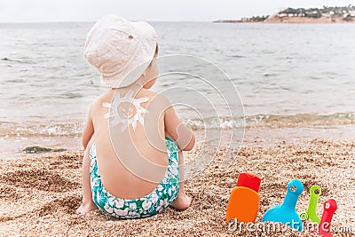 The sun drawing sunscreen on baby (boy) back. Stock Photo