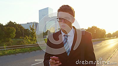SUN FLARE: Stressed yuppie looks around the city as he walks home at sunset. Stock Photo