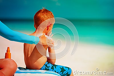 Sun protection -mother applying sunblock cream on son shoulder Stock Photo