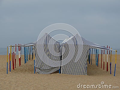 sun protection tents on the sand of the bathing beach in the town of Nazaré Stock Photo