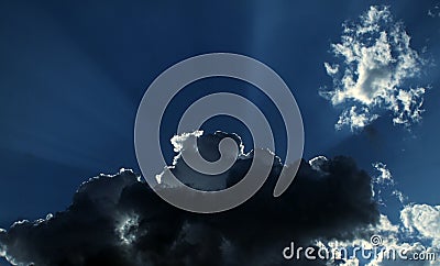 Sun rays behind stormy clouds Stock Photo