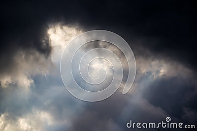 The sun rays break through dark thunder clouds Stock Photo