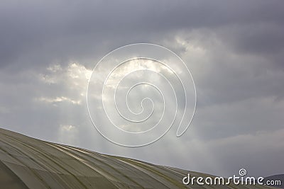 Sun rays breaking through the clouds over a mountain landscape Stock Photo