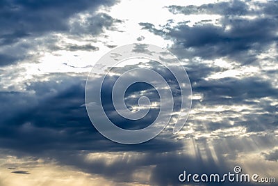 Sun rays breaking through cumulus clouds. The concept of divine light, a glimmer of hope or overcoming difficulties. Spiritual Stock Photo