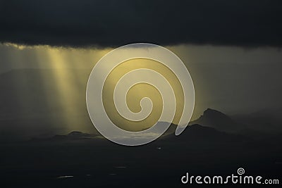 Sun rays through the clouds over the mountains Stock Photo