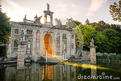 Sun rays pass through the gates of Valsanzibio garden on water pond Stock Photo