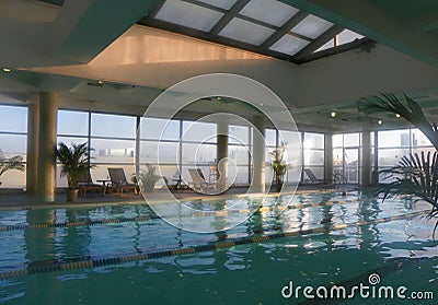 Rooftop hotel swimming pool as sunrise filters through windows Stock Photo