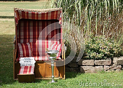 Sun, roofed wicker beach chair and a chilled bottle of champagne Stock Photo