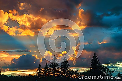 The sun`s rays and twilight beauty of the evening colorful clouds. Dramatic sky. Stock Photo