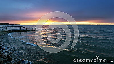 The sun sank behind the horizon of the sea, the last gleam of rays on the waves. Stock Photo