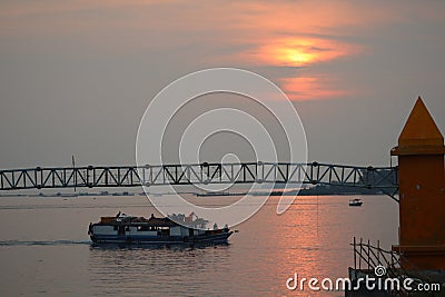 The sun sets as seen by the ship and tower Stock Photo
