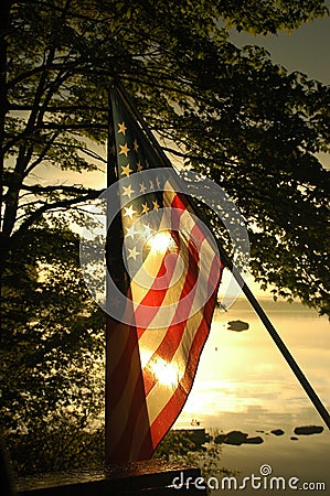 Sun Sets Behind American Flag Stock Photo