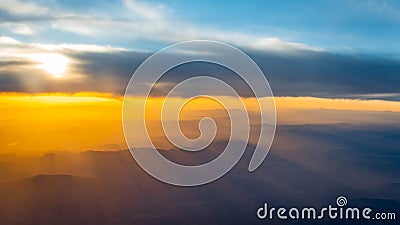 Sunset of a cloudy sky seen from an airplane mid flight Stock Photo