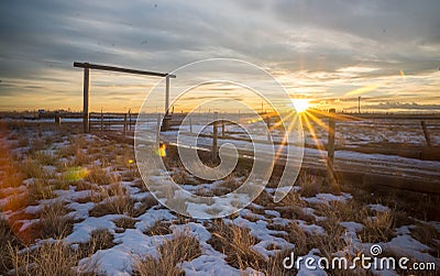 Sunset Behind Country Wooden Gated Driveway Entrance in Farm and Ranch Land of Colorado Stock Photo