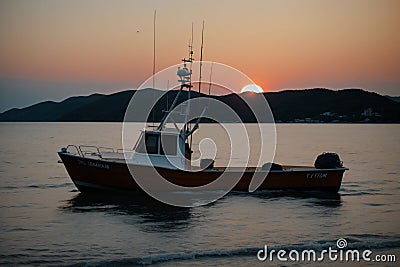 Sun setting behind a quiet fishing boat Stock Photo
