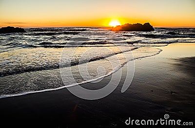 Sun Setting Behind a Seastack on the Oregon Coast Stock Photo